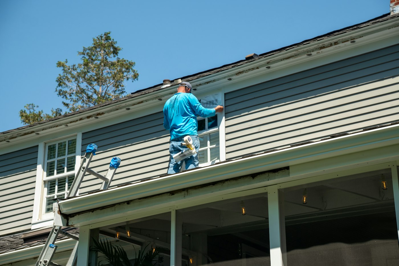 Peintre travaillant sur le revêtement extérieur d'une maison